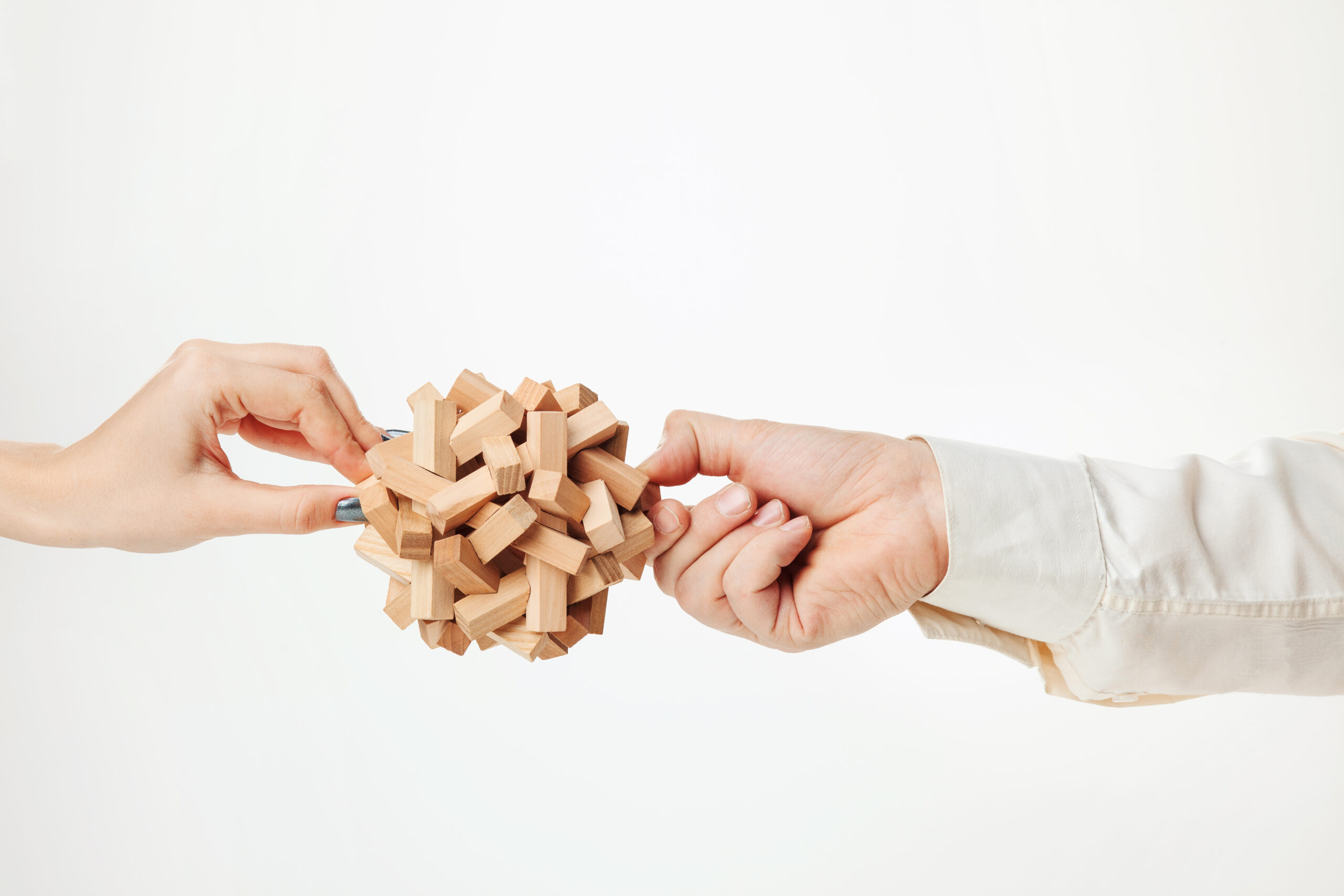 The toy wooden puzzle in hands isolated on white background